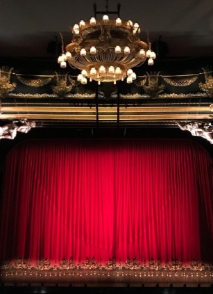 Interior elegante de un teatro con cortinas rojas