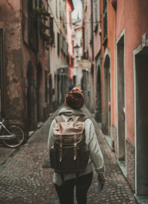 Person walking through a narrow alley in a city